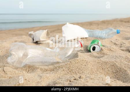 Müll verstreut am Strand in der Nähe des Meeres, dicht gemacht. Recycling-Problem Stockfoto