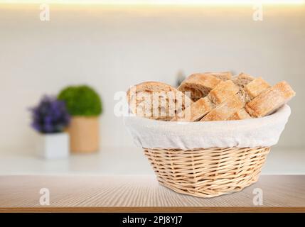 Frisches Brot im Korb auf einem Holztisch in der Küche. Platz für Text Stockfoto