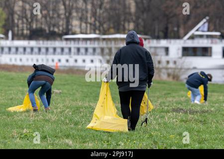 Dresden, Deutschland. 01. April 2023. Eine Frau mit einem Greifer am Tag der Elbwiese-Reinigung in der Stadt Dresden. Das Einsatzgebiet erstreckt sich auf beiden Seiten der Elbe von Cossebaude bis Pillnitz und ist insgesamt 30 km lang. Kredit: Daniel Schäfer/dpa/Alamy Live News Stockfoto