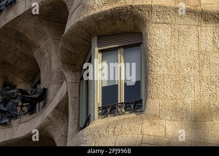 Detail eines Fensters und der Steinfassade, die dem Casa Milà (Barcelona, Katalonien, Spanien) den Spitznamen La Pedrera verliehen hat Stockfoto