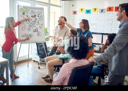 Eine Gruppe junger Mitarbeiter diskutiert bei einer Besprechung in einer Arbeitsatmosphäre im Büro. Mitarbeiter, Job, Büro Stockfoto