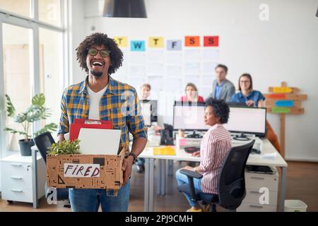 Junger, unachtsamer Afro-amerikaner, der aus dem Büro gefeuert wird Stockfoto