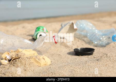 Müll verstreut am Strand in der Nähe des Meeres, dicht gemacht. Recycling-Problem Stockfoto