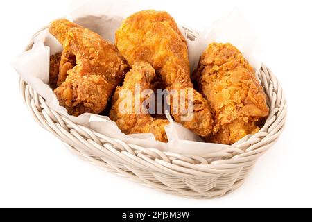 Knusprig gebratene Hähnchenstücke in einem weißen, auf Weiß isolierten Korb. Stockfoto