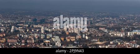 Panoramablick auf die Stadt Banja Luka an sonnigen Tagen, Luftverschmutzung in der Stadt, entfernte Hügel verblassen im Dunst Stockfoto