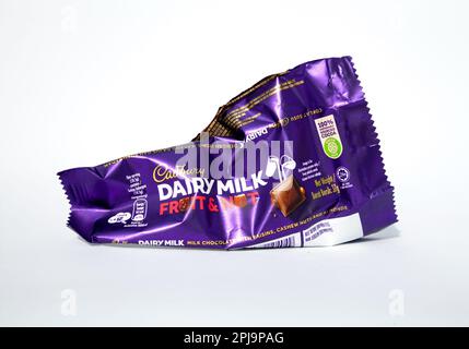 Ho-Chi-Minh-Stadt, Vietnam - 28. März 2023: Cadbury Milchmilchobst und Nuss Schokoladenriegel leere, zerknitterte Verpackung isoliert auf weiß. Beliebte Süßigkeiten purpl Stockfoto