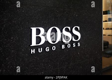 Ho-Chi-Minh-Stadt, Vietnam - 28. März 2023: Handelsschild für Modegeschäfte mit schwarz-weißem Hugo Boss-Logo. Berühmtes Logo der Luxusmarke Stockfoto