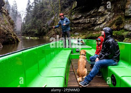 Hrensko, Tschechische Republik. 01. April 2023. Eröffnung der Tourismussaison in Hrensko in der Region Decin mit dem Betrieb von Booten auf dem Fluss Kamenice; Die aufgrund der Folgen des massiven Feuers im Tschechischen Schweizer Nationalpark im letzten Jahr nur vom unteren Dock in der Divoka-Schlucht im Kreisverkehr segeln, 1. April 2023, Decin-Region. Der Fährmann Tomas Sabol (links) trägt die ersten Touristen auf dem Boot. Kredit: Ondrej Hajek/CTK Photo/Alamy Live News Stockfoto