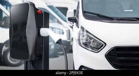 Elektrischer Lieferwagen mit Ladestation für Elektrofahrzeuge. Hochwertiges Foto Stockfoto