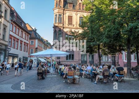 Gäste im Café und in der Bar in der historischen Hauptstraße der Altstadt. Heidelberg. Stockfoto