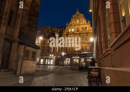 Gäste im Café oder in der Bar des historischen 16. Cent mittelalterlichen Hotels zum Ritter in der Hauptstraße in der Altstadt vom Fischmarkt in der Nacht oder in der Abenddämmerung. Heidelberg. Stockfoto