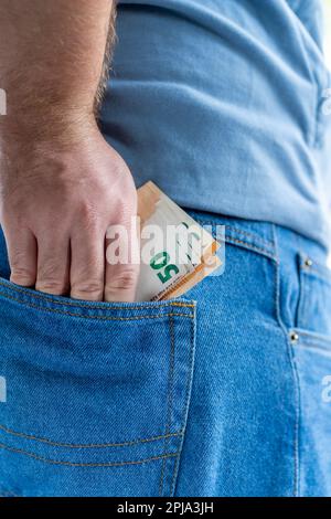 Männerhand mit 50-Euro-Banknoten in der Rückentasche aus Jeans Stockfoto