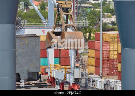 Eine Kranschaufel im Hafen über dem Bulkentransportdeck. Stockfoto