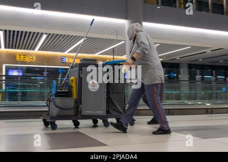 ISTANBUL, TÜRKEI, JANUAR 19 2023, das Personal schiebt einen Wagen mit Reinigungsmitteln im Nachtflughafen Stockfoto