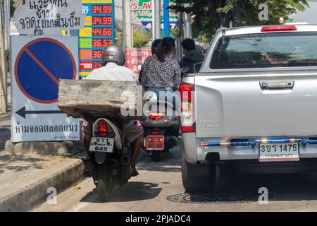 SAMUT PRAKAN, THAILAND, JANUAR 21 2023, Ein Motorrad fährt auf der Straße in einer Lücke zwischen Autos und Gehweg. Stockfoto