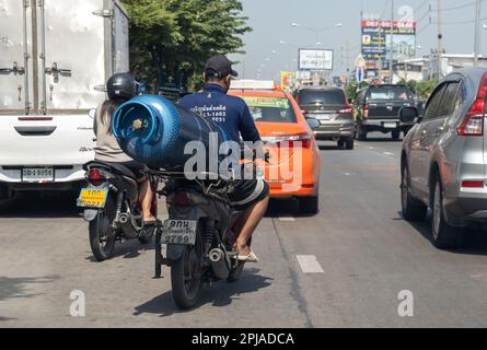 SAMUT PRAKAN, THAILAND, JANUAR 21 2023, Ein Mann transportiert eine große Gasflasche auf einem Motorrad Stockfoto