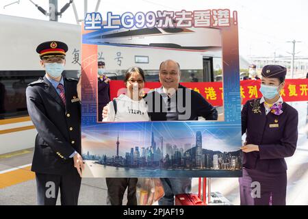 Schanghai. 1. April 2023. Passagiere posieren für Fotos, bevor sie am Shanghai Hongqiao Railway Station im Osten Chinas Shanghai am 1. April 2023 in den Zug G99 einsteigen. Als der Zug G99 den Bahnhof Shanghai Hongqiao zur Hong Kong West Kowloon Station verließ, wurde der Hochgeschwindigkeitszug Shanghai-Hong Kong am Samstag wieder aufgenommen. Kredit: Wang Xiang/Xinhua/Alamy Live News Stockfoto