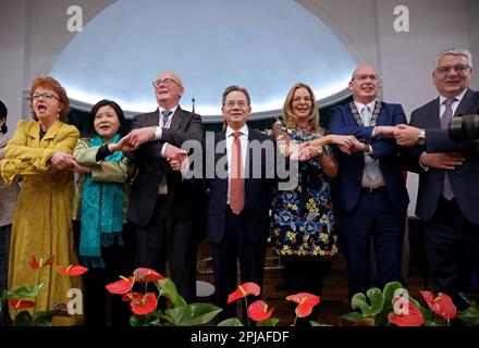 (230401) -- BELFAST, 1. April 2023 (Xinhua) -- Chinese Ambassador to the United Kingdom (UK) Zheng Zeguang (C), Lord Mayor of Belfast City Council Christina Black (3. R), und andere Gäste singen das Lied "Auld lang Syne" Hand in Hand in Belfast, Nordirland, Vereinigtes Königreich, 27. März 2023. ZU „Roundup: N. irische Beamte, Akademiker erwarten stärkere Beziehungen zu China“ (Xinhua/Li Ying) Stockfoto