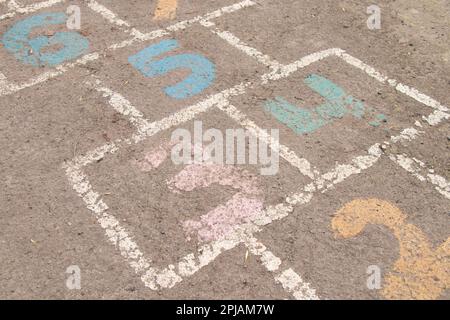 Kinderspiel auf Asphalt, Zahlen werden mit Farbe auf Asphalt gemalt Stockfoto