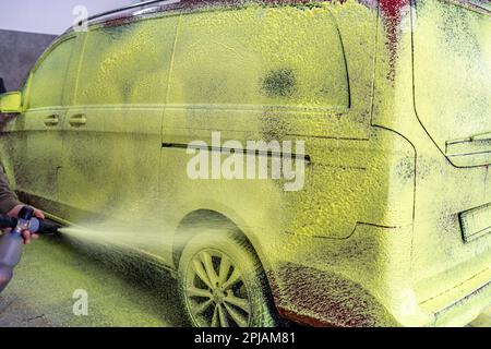 Die Autos in der Garage mit grünem Aktivschaum waschen Stockfoto