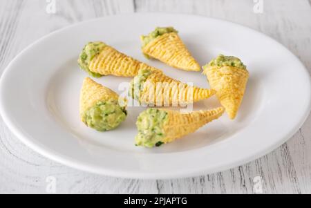 Tortilla-Chips, gefüllt mit Guacamole auf dem Teller Stockfoto