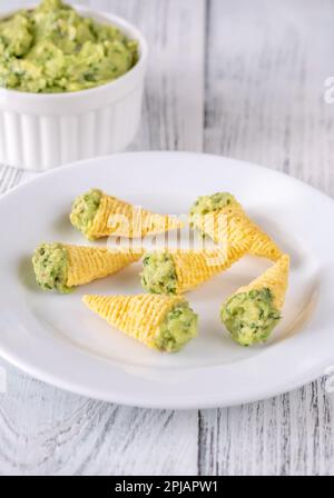 Tortilla-Chips, gefüllt mit Guacamole auf dem Teller Stockfoto