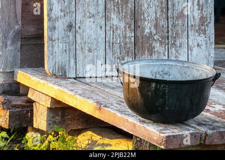 Ein schwarzer Eimer auf einem Holztisch Stockfoto