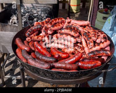 Spanische traditionelle frische rote und weiße Würste in der Bratpfanne auf dem Jahrmarkt Stockfoto