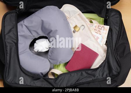 International Travel Concept, packen Koffer oder Tasche mit Travel Pillow, Adapter, Pass, Geld Riemen Stockfoto