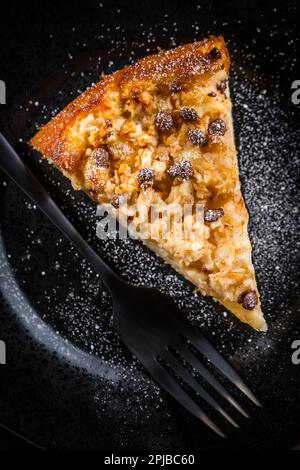 Ein Stück hausgemachter Apfelkuchen mit Schokoladenstücken für Thanksgiving auf schwarzem Teller Stockfoto