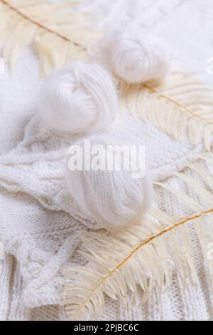 Strickkonzept mit Nadeln, Wolle, Pullover und Garn in weißer Farbe Stockfoto