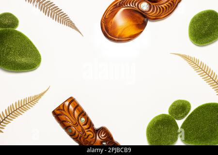 Neuseeland, Landessymbole, traditionelle Maori-Schnitzereien, silberne Farnblätter, weißer Hintergrund, Kopierbereich, flach liegend, Reisekonzept Stockfoto