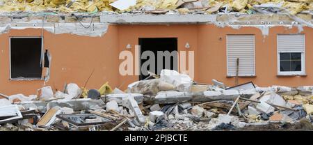 Zerstörtes Haus mit Trümmern im Vordergrund im Panoramafenster Stockfoto