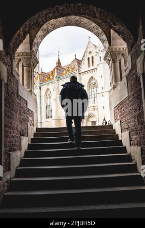 Ein Mann, der in der Fischerbastei im Herzen des Burgviertels Budas in Budapest, Ungarn, ankommt Stockfoto