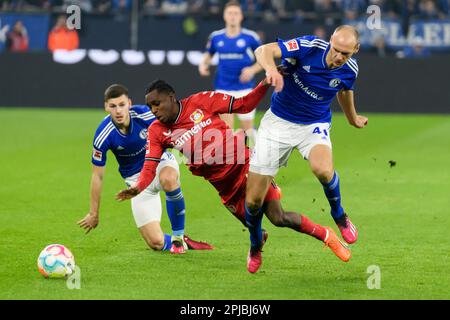 JEREMIE FRIMPONG (l., LEV) gegen Henning MATRICIANI (GE), hinter Tom KRAUSS (GE), Action, Kampf um den Ball, Fußball 1. Bundesliga, 26. Spieltag, FC Schalke 04 (GE) - Bayer 04 Leverkusen (LEV ) 0: 3, am 1. April 2023 in Gelsenkirchen/Deutschland. Stockfoto