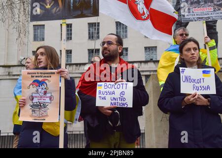 London, Großbritannien. 01. April 2023. Demonstranten halten während der Demonstration außerhalb der Downing Street Plakate gegen die russische Präsidentschaft des UN-Sicherheitsrates. Pro-ukrainische Demonstranten versammelten sich, um gegen Russland zu protestieren, das den Vorsitz des UN-Sicherheitsrates für den Monat April übernommen hat. Kredit: SOPA Images Limited/Alamy Live News Stockfoto