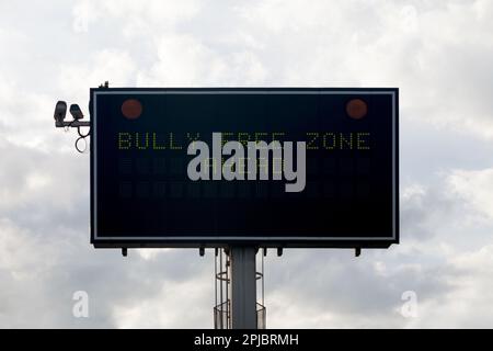 Informationstafel auf der Straße mit der Meldung „Bully Free Zone Ahead“. Stockfoto