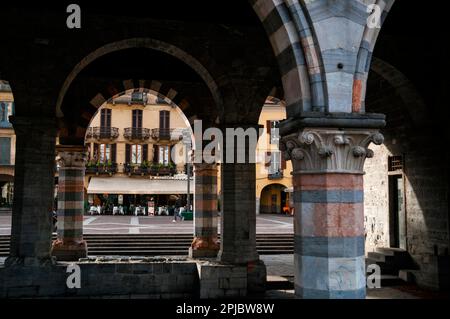 Italienische Cafés in der Nähe des romanisch-gotischen polychromen Marmors des mittelalterlichen Rathauses oder des Broletto auf der Piazza del Duomo in Como, Italien. Stockfoto