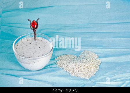 Sesammilch in einem Glasbecher auf blauem Hintergrund Stockfoto