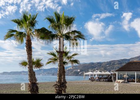 Salobreña, Spanien; Januar-11, 2023: Blick auf eine typische Chiringuito an einem Strand an der Küste von Granada (Spanien) mit Menschen, die am Meer essen Stockfoto