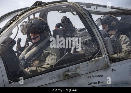 AUF SEE, KOREA STRAIT (29. MÄRZ 2023) – USA Marinekorps Oberst Samuel Meyer, Left, kommandierender Offizier der 13. Marineexpeditionstruppe, Co-Pilot eines AH-1Z Venom Hubschraubers während des Starts vom Amphibienschiff USS Makin Island (LHD 8), 29. März 2023. Die 13. MEU wird von der Makin Island Amphibious Ready Group gestartet, die sich aus der Makin Island und den Amphibien-Transportdocks USS John P. Murtha (LPD 26) und USS Anchorage (LPD 23) zusammensetzt und im US-Flottengebiet 7. tätig ist. 7. Fleet sind die USA Der größte Stürmer der Navy hat eine nummerierte Flotte, routinemäßig Stockfoto