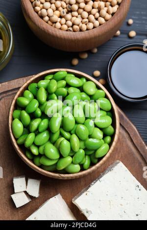 Verschiedene Bio-Soja-Produkte auf grauem Holztisch, flach liegend Stockfoto