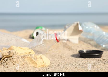 Müll verstreut am Strand in der Nähe des Meeres, dicht gemacht. Recycling-Problem Stockfoto