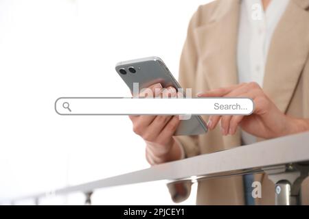 Suchleiste für Website und Frau, die ein modernes Smartphone in Innenräumen verwendet, Nahaufnahme Stockfoto