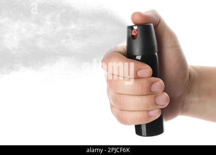 Ein Mann, der Pfefferspray auf weißem Hintergrund benutzt, Nahaufnahme Stockfoto