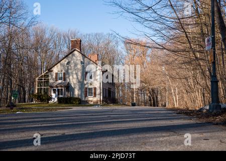 Fenster mit Holzläden und Blumen vor einer Steinmauer. Architekturdetails Stockfoto