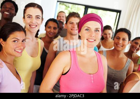In Form zu bleiben, macht sie glücklich. Porträt einer Gruppe Yoga-Enthusiasten, die in einem Yoga-Studio stehen. Stockfoto