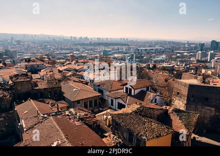 Panoramablick auf geflieste Dächer historischer Wohngebäude im Vordergrund und moderne Hochhäuser im Hintergrund. Panoramablick auf ank Stockfoto