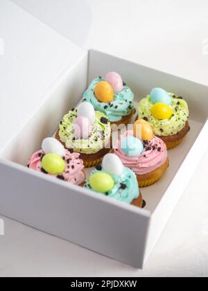 handgemachte muffins in osterpastelltönen mit Konfetti-Schokoladeneiern Stockfoto