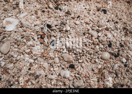 Konsistenz von winzigen beigen Strandkieseln. Natürlicher Hintergrund Stockfoto